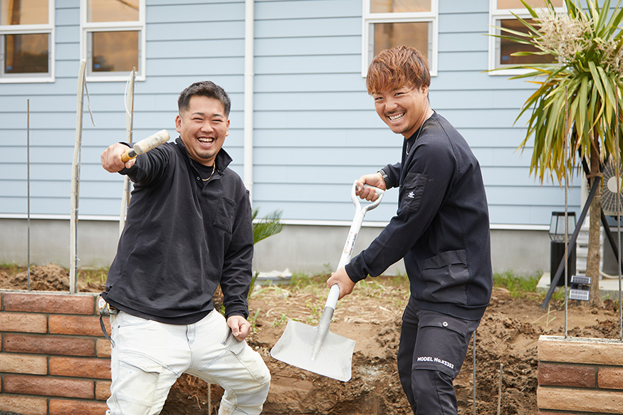 笑顔でポーズをとる２人の職人