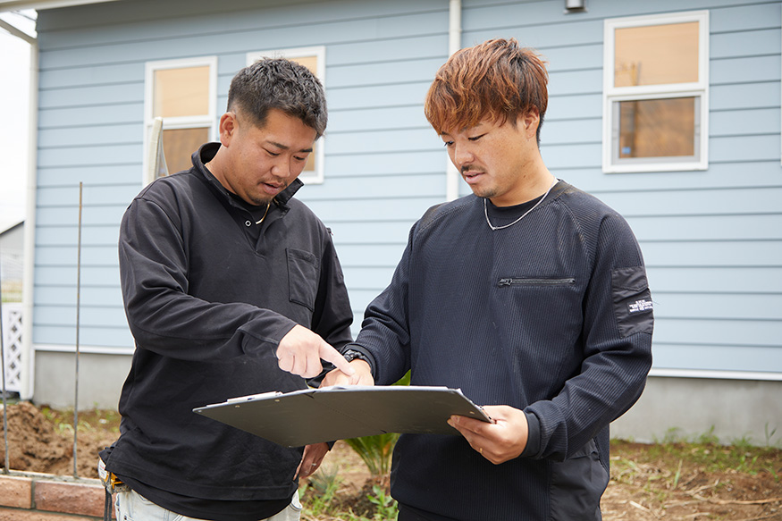 書類を確認しながら作業を進める２人の職人